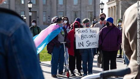 An attendee holds a sign reading &quot;Trans kids belong in sports,&quot; at the Transgender Day of Visibility Rally in March in Iowa City, Iowa.