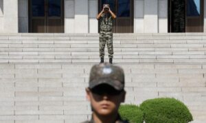 A North Korean soldier looks toward the south as a South Korean soldier stands guard in the truce village of Panmunjom