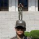 A North Korean soldier looks toward the south as a South Korean soldier stands guard in the truce village of Panmunjom