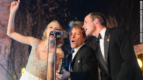 Britain's Prince William, Duke of Cambridge (right), sings with Taylor Swift (left) and Jon Bon Jovi (center) at the Centrepoint Gala Dinner at Kensington Palace in London, November 26, 2013.  