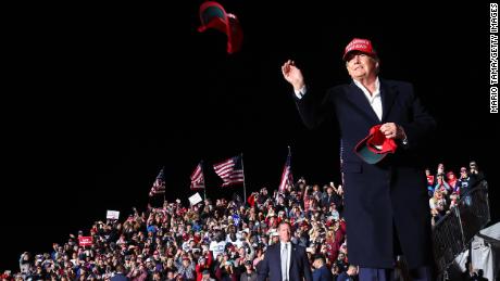 Former President Donald Trump tosses a MAGA hat to the crowd before speaking at a rally on Saturday, January 15, 2022 in Florence, Arizona.