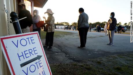 Voters stand in line to cast their ballots during the first day of early voting in the US Senate runoff election on December 14, 2020, at the Gwinnett Fairgrounds outside Atlanta.