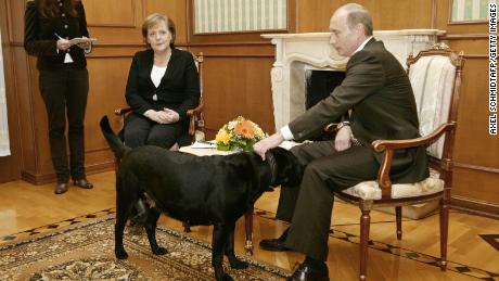 Russian President Vladimir Putin pets his dog during a press conference with German Chancellor Angela Merkel in Sochi, 2007. 