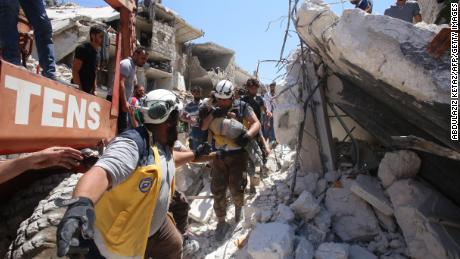 Members of the Syrian civil defence, known as the White Helmets, pull out a child from under the rubble following a reported Russian air strike on Maaret al-Numan in Syria's Idlib province in 2019. 